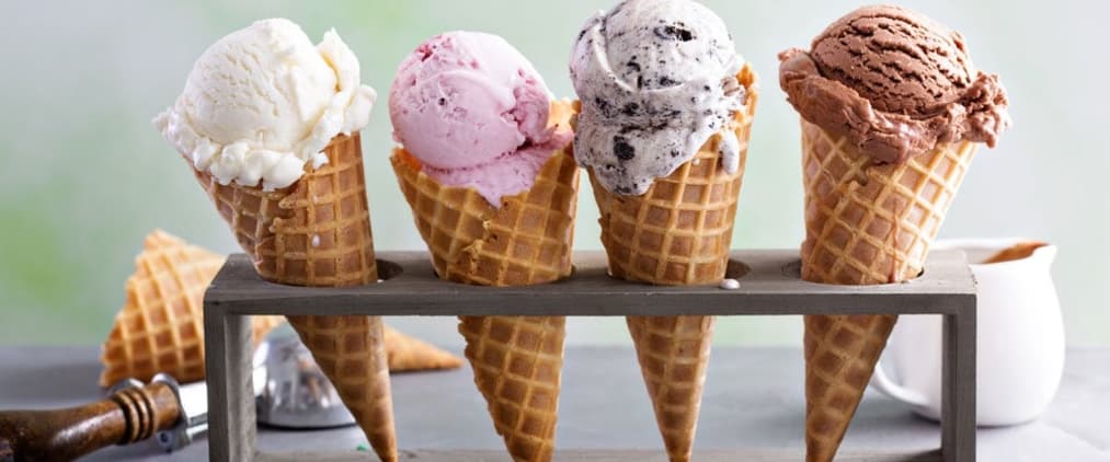 Colorful ice cream cones sitting in an ice cream rack.